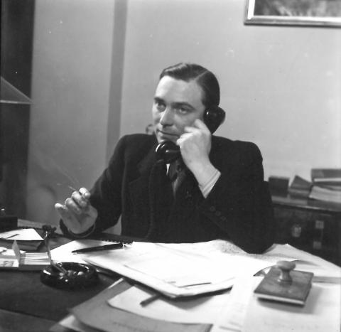 Mann am Schreibtisch, telefonierend, Schwarz-Weiß-Foto
