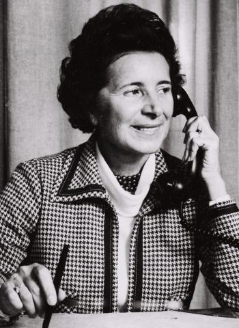 Frau mit Telefonhörer am linken Ohr, Schwarz-Weiß-Foto