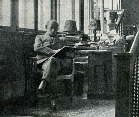 Jehudo Epstein liest in einem Sessel vor einem Schreibtisch sitzend, Schwarz-Weiß-Foto