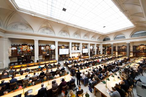 Saal mit großer Oberlichte, zahlreiche Lesende an Tischen, Farbfoto