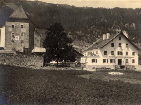 Turm der Burg, Baum und Haus, im Hintergrund Wald, Schwarz-Weiß-Foto