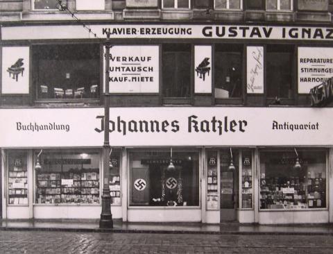 Fassade mit Schaufenstern, u. a. Aufschrift "Buchhandlung Johannes Katzler Antiquariat", Schwarz-Weiß-Foto